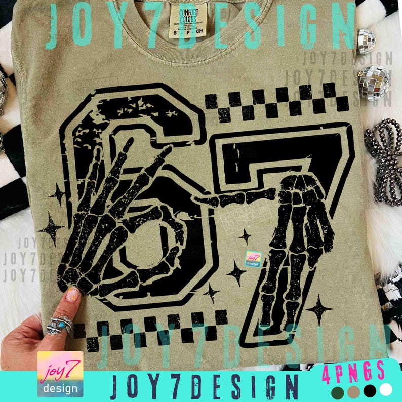 Peut inclure: T-shirt vert olive avec un motif noir du chiffre 67, stylis&eacute; avec des mains de squelette. Le t-shirt a un col rond et des manches courtes. Le texte "JOY7DESIGN" est visible.