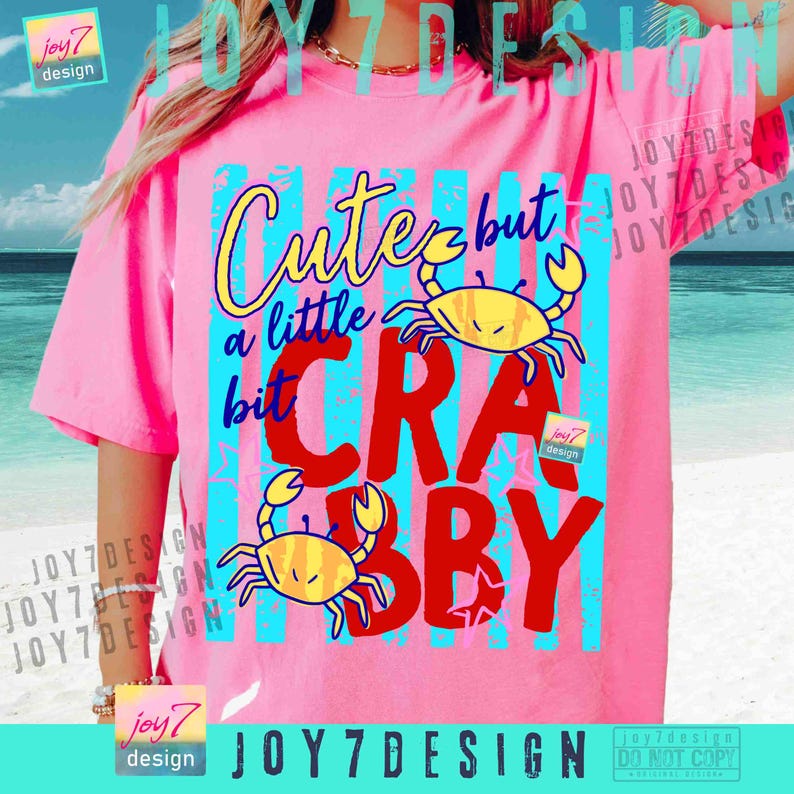 May include: Pink t-shirt with the text "Cute but a little crabby" in yellow, blue, and red. The design includes two yellow cartoon crabs. The shirt has short sleeves.