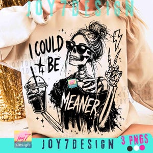 May include: Beige sweatshirt with a black and white graphic of a skeleton wearing sunglasses, holding a drink, and giving a peace sign. Text reads "I COULD BE MEANER". Stars and lightning bolt accents.
