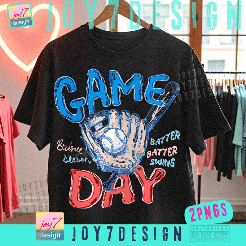 May include: Black t-shirt with a baseball-themed graphic. The design features the words "GAME DAY" in blue and red, along with a baseball, glove, and bat illustration. Additional text includes "Baseball Season", "Batter, Batter, Swing".