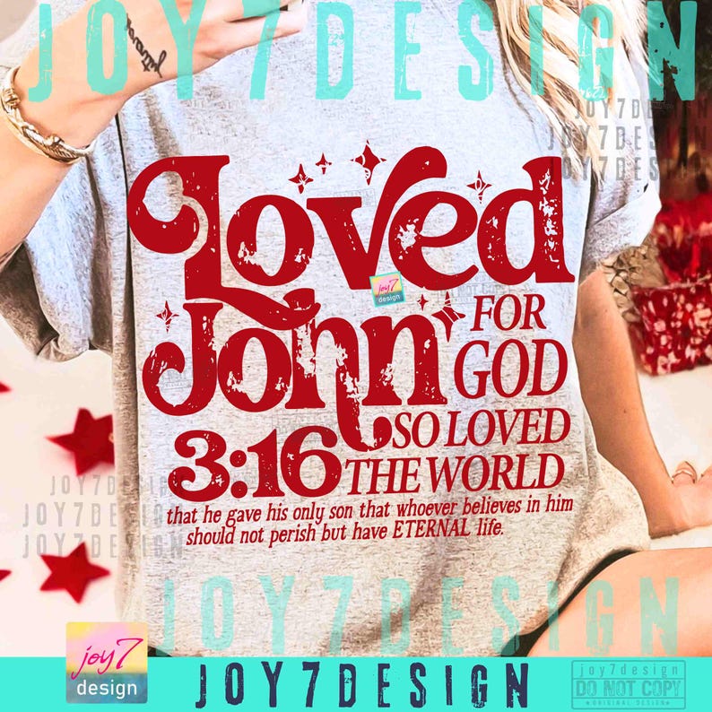 Op de afbeelding: Lichtgrijs t-shirt met een grote rode opdruk. De opdruk bevat de woorden "Loved John 3:16 For God So Loved The World", evenals een Bijbelvers: "that he gave his only son that whoever believes in him should not perish but have ETERNAL life."