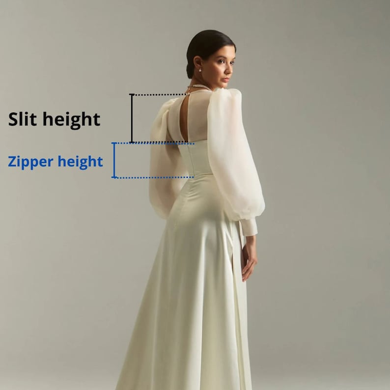 May include: A white satin dress with a sheer overlay and a back zipper. The dress has a high slit and a fitted bodice.