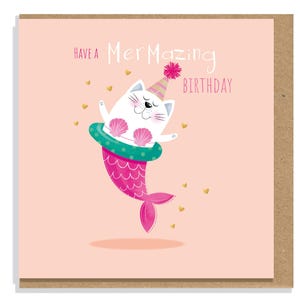 May include: A square greeting card with a light pink background featuring a white cat dressed as a mermaid with a pink tail, a teal inner tube, and a party hat. The text reads "HAVE A MERMAZING BIRTHDAY" with small gold heart accents.