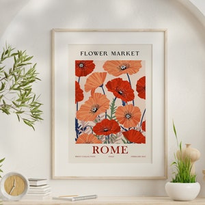 Puede incluir: Un póster enmarcado con un diseño floral con amapolas rojas y naranjas. El póster tiene el texto "FLOWER MARKET" y "ROME" impreso en él.