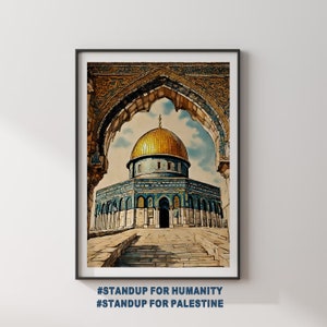 May include: A framed watercolor painting of the Dome of the Rock in Jerusalem, a gold dome with blue and green tiles, seen through an ornate archway. The caption below reads "#STANDUP FOR HUMANITY #STANDUP FOR PALESTINE".
