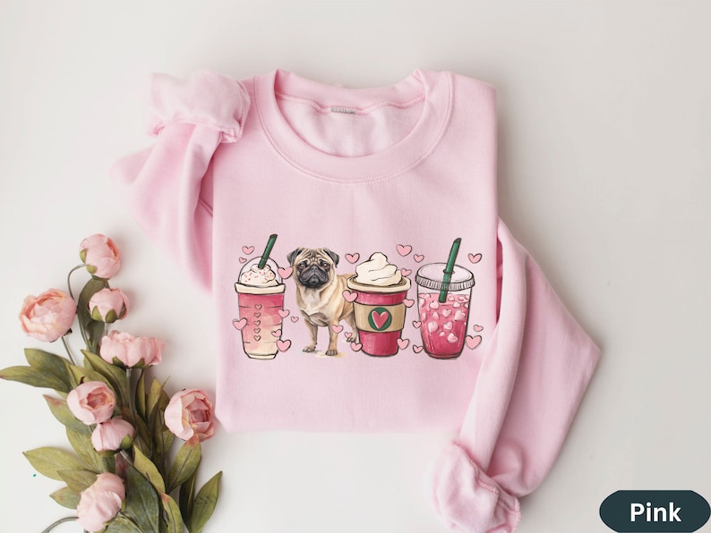 May include: Pink sweatshirt with a graphic of a pug dog and three iced coffee drinks with hearts. The drinks are labeled with hearts and the text "Love"