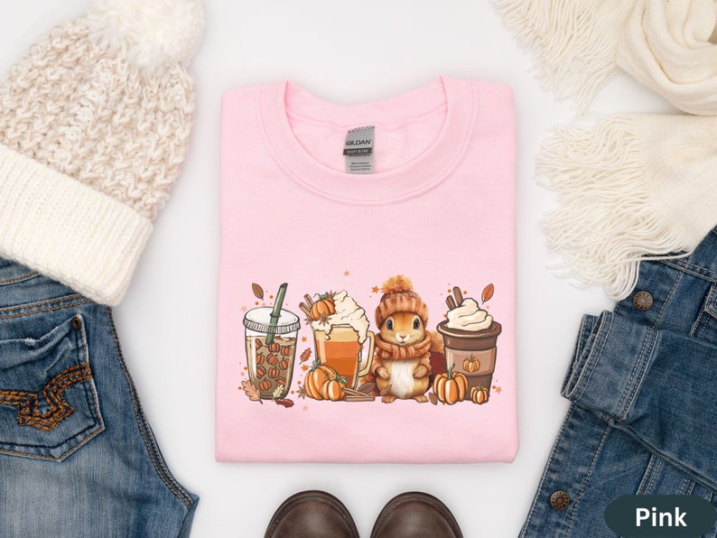 May include: Pink sweatshirt with a graphic of a squirrel holding a cup of coffee and surrounded by fall leaves and pumpkins. The text "Gilded" is visible on the tag.