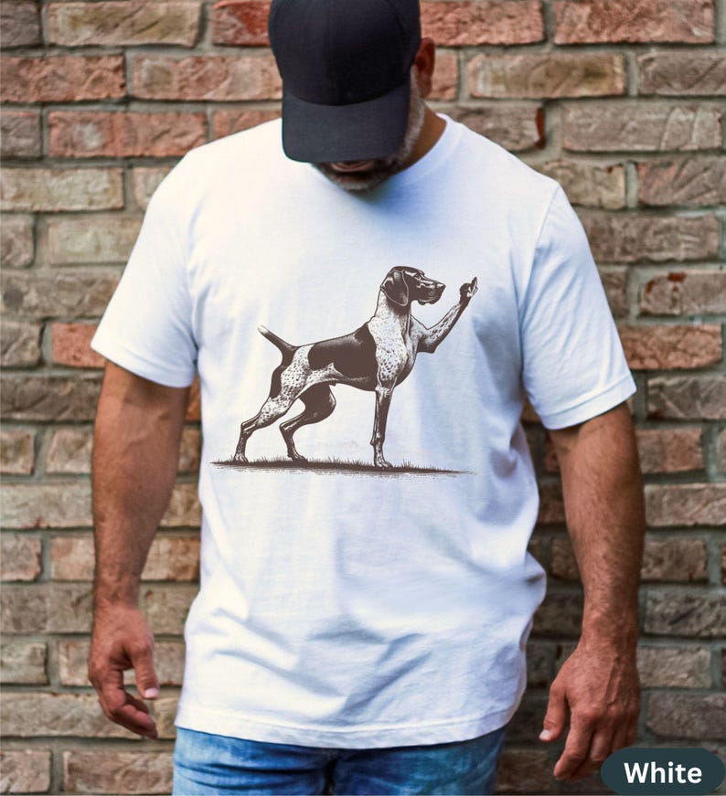 May include: White t-shirt with a black and white illustration of a dog giving a thumbs up.