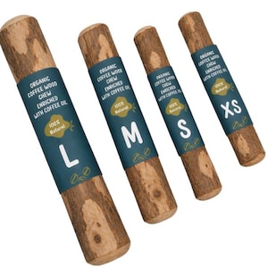 Könnte beinhalten: Vier organische Kaffeebaum-Kauspielzeuge für Hunde in den Größen L, M, S und XS. Jedes Kauspielzeug hat eine natürliche Holzfarbe mit einem dunkelblauen Etikett mit der Aufschrift "Organic Coffee Wood Chew Enriched with Coffee Oil 100% Natural."