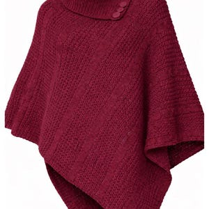 May include: A burgundy knit poncho with a turtleneck collar and three decorative buttons. The poncho features a textured knit pattern and a draped, asymmetrical design, perfect for layering.