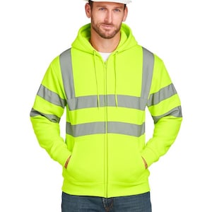 May include: A fluorescent yellow zip-up hoodie with grey reflective stripes. The hoodie has a hood, front pockets, and a white hard hat. The person is wearing blue jeans.