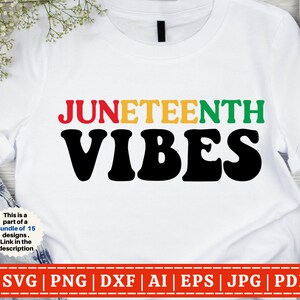 Puede incluir: Camiseta blanca con el texto "JUNETEENTH VIBES" en letras negras, rojas, amarillas y verdes. El texto está en un estilo de fuente retro.