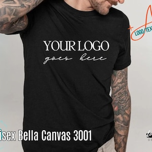 May include: Black t-shirt with the text "YOUR LOGO goes here" in white. The shirt also has the text "Unisex Bella Canvas 3001". The image includes the text "Add LOGO/TEXT/DESIGN/QR".