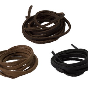 May include: Three coiled bundles of leather strips in shades of brown and black. The strips are flat and narrow, ideal for crafts or jewellery making. The colours include dark brown, light brown, and black.