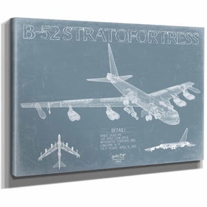 May include: A canvas print of a B-52 Stratofortress blueprint. The image features a detailed wireframe illustration of the aircraft, with text including "DETAILS" and specifications like range and top speed. The background is a muted blue.