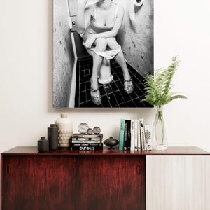 Framed bathroom humor artwork, a perfect lighthearted print for powder rooms, bars, or man caves.