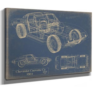 May include: A rectangular wall art print featuring a blue background with gold-toned technical line drawings of a 1963 Chevrolet Corvette C2. The print displays three views of the car, including perspective, side, and top, with the text Chevrolet Corvette C2 1963.