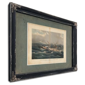 May include: Framed nautical print depicting a ship at sea during a storm. The artwork features a detailed illustration of a clipper ship battling rough waves under a cloudy sky. The print is encased in a black ornate frame.