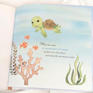 May include: An illustrated page from a children's book features a smiling green turtle swimming above orange fish and coral. Text reads "Meet the turtle, so peaceful of mind, teaches us to slow down and enjoy life one step at a time."