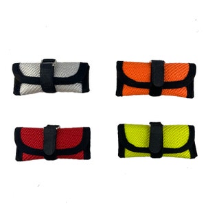 Può includere: Quattro piccole pochette con cerniera, con cinturini neri e bordi neri. Le pochette sono realizzate in tessuto intrecciato e sono disponibili in quattro colori: argento, arancione, rosso e giallo.