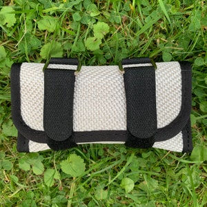 Può includere: Supporto per polso imbottito bianco con due cinturini neri regolabili e fibbie argentate.