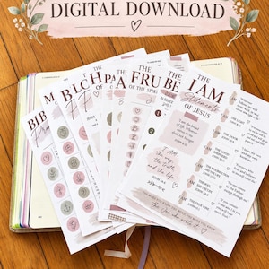Peut inclure: Un ensemble de feuilles de papier blanches présentant des textes religieux et des illustrations, dont "The I Am Statements of Jesus" et "The Fruit of the Spirit". Les pages contiennent des listes, des icônes circulaires et des écritures en rose et marron.