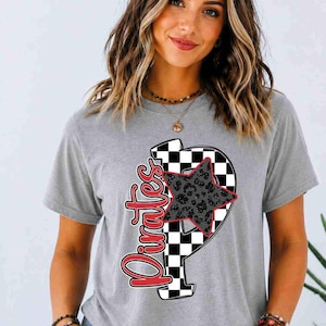 May include: A heather gray short-sleeve t-shirt featuring a large letter P with a black and white checkered pattern. The letter is overlaid with a gray leopard print star and the word Pirates written in red script with a white outline.