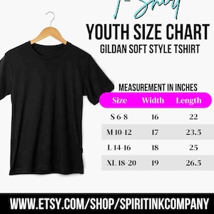 Puede incluir: Una camiseta negra de manga corta en una percha de madera junto a una tabla de tallas juveniles para camisetas Gildan Soft Style. La tabla enumera las tallas S, M, L y XL con medidas de ancho y largo en pulgadas. Texto: WWW.ETSY.COM/SHOP/SPIRITINKCOMPANY.