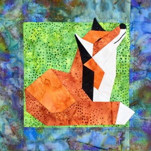 May include: A patchwork quilt block featuring a stylised fox with orange, white and black fabric. The fox is lying down with its head tilted up. The background is a green fabric with white polka dots.