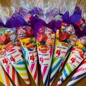 May include: A collection of cone-shaped party favor bags filled with assorted candies, including Swedish Fish and Blow Pops. Each clear plastic bag is tied with a purple ribbon and features a label that reads: Thank you for attending my 4th birthday! Xoxo, Peyton.