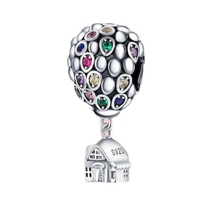 Peut inclure: Charme en argent représentant un ballon à air chaud avec une maison suspendue. Le ballon est décoré de pierres précieuses colorées et la maison a une petite fenêtre et le texte "S925".