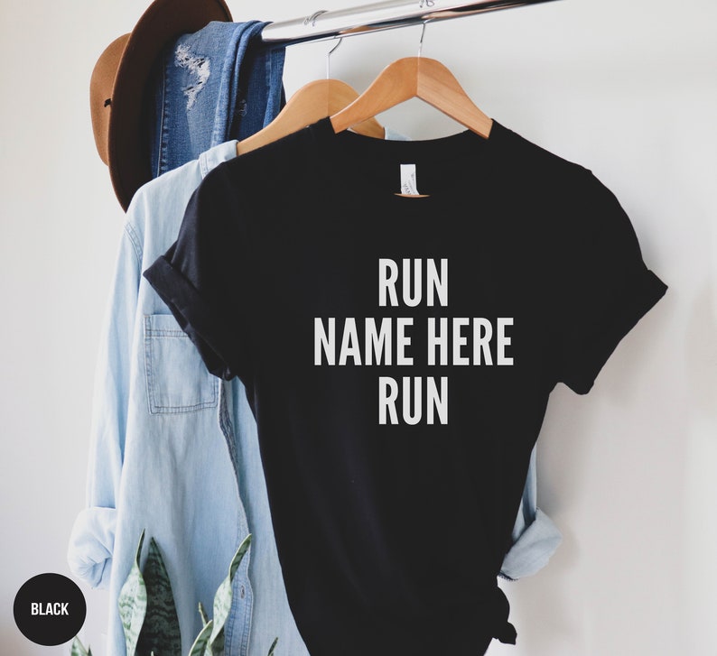 May include: Black t-shirt with white text that reads "RUN NAME HERE RUN".