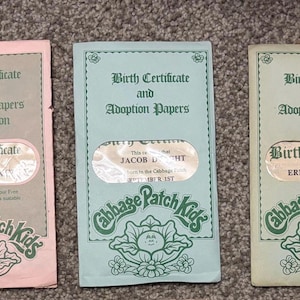 May include: Five vintage Cabbage Patch Kids birth certificates and adoption papers. Each certificate is a different pastel colour, with green text and a cabbage logo. The certificates include the text "Birth Certificate and Adoption Papers Application."