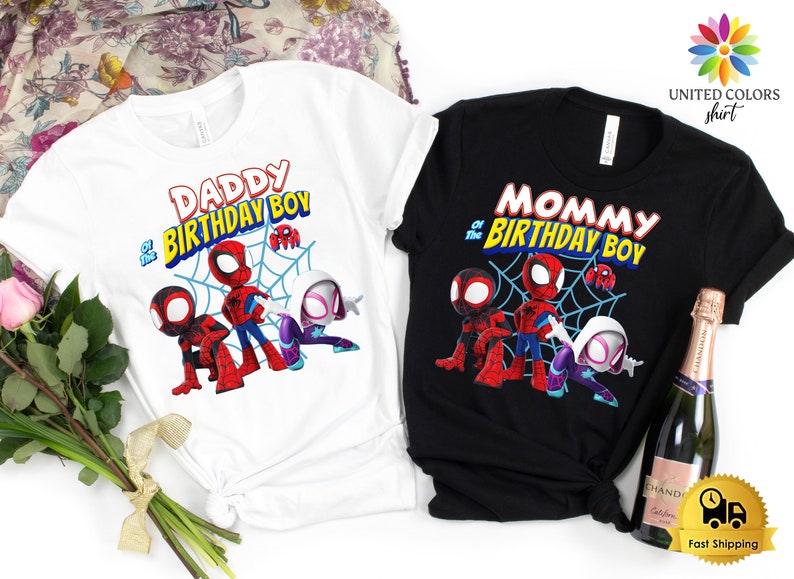 以下が含まれることがあります： スパイダーマンのデザインが施された白と黒のTシャツ2枚。白いシャツには「DADDY of the BIRTHDAY BOY」、黒いシャツには「MOMMY of the BIRTHDAY BOY」と書かれています。どちらのシャツにもスパイダーマンのグラフィックが描かれています。