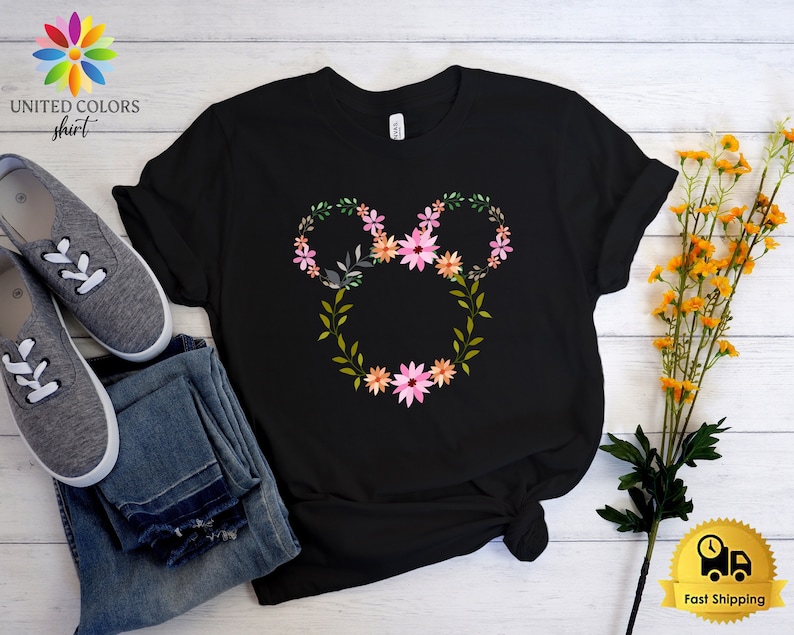 May include: Black t-shirt with a floral design in the shape of Mickey Mouse ears. The flowers are pink, orange, and green.