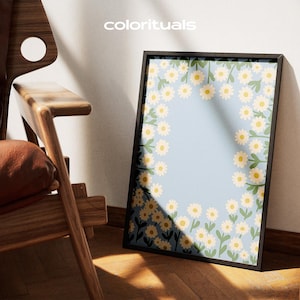 Peut inclure: Une impression encadrée rectangulaire présentant un fond bleu clair avec une bordure de marguerites blanches à cœur jaune et tiges vertes. Le texte colorituals est imprimé en blanc en haut au centre de l'image au-dessus de l'œuvre encadrée.