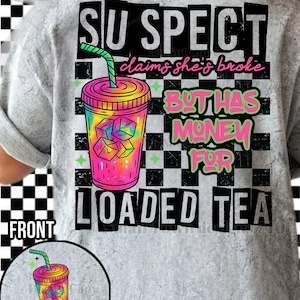 May include: A light grey t-shirt featuring a vibrant graphic of a drink with ice cubes and a straw. The text on the shirt reads "SUSPECT claims she's broke BUT HAS MONEY FOR LOADED TEA."