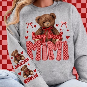 May include: A gray sweatshirt features a brown teddy bear with a red bow, the words "beary loved," and the name "MIMI" in a mix of patterns. The sleeve displays teddy bears and the names "Jackson" and "Amelia."