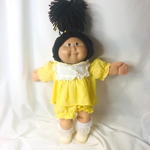 Muñeca Cabbage Patch Kid HM15 OAA Hong Kong, fabricada en Hong Kong, Oklahoma, color rojo, con vestido amarillo y cabello raro.