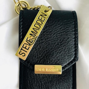 Minitarjetero Steve Madden negro con herrajes dorados y llavero con etiqueta para bolso de piel sintética negra