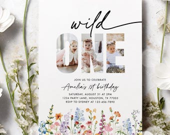 May include: A white invitation card with the words "wild ONE" and three photos of a baby. The card is decorated with colorful floral illustrations at the bottom and surrounded by white flowers and greenery. The text reads "Amelia's 1st birthday".