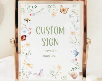 Op de afbeelding: Een printbaar bord van 20,3 x 25,4 cm met een bloemige rand en verschillende insecten, waaronder een lieveheersbeestje, een vlinder, een libel en een slak. Het bord heeft de tekst "Custom Sign" in groene letters.