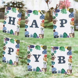 May include: A banner with the word "HAPPY" spelled out on individual flags. Each flag has a white background with a border of colorful gemstones.