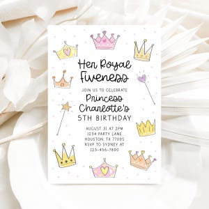 Pu&ograve; includere: Un biglietto d'invito bianco con la scritta "Her Royal Fiveness" e "5&deg; compleanno della principessa Charlotte". Il biglietto presenta corone disegnate a mano, una bacchetta e una stella. L'invito include data, ora e luogo.