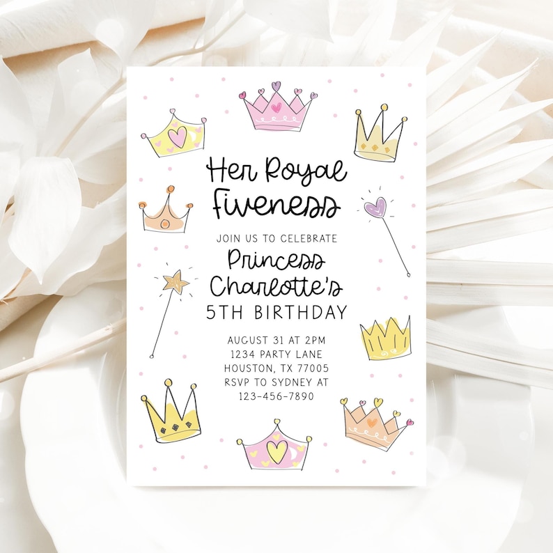 Pu&ograve; includere: Un biglietto d'invito bianco con la scritta "Her Royal Fiveness" e "5&deg; compleanno della principessa Charlotte". Il biglietto presenta corone disegnate a mano, una bacchetta e una stella. L'invito include data, ora e luogo.