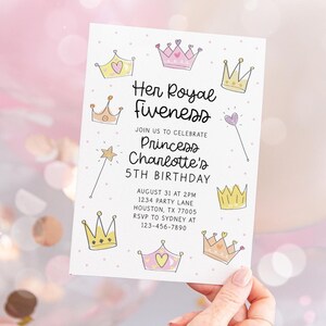 Pu&ograve; includere: Un biglietto d'invito bianco a tema principessa. La carta presenta corone disegnate a mano, una bacchetta magica e il testo "Her Royal Fiveness" e "5&deg; compleanno della principessa Charlotte". La carta &egrave; tenuta in mano.