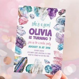 May include: A colorful invitation with a crystal theme. The invitation says "She's a Gem! Olivia is turning 7. Join us for a rockin' party August 31 at 3 PM. Olivia's House 1234 Party Lane, Houston, TX 17005 RSVP to Sydney at 123-456-7890"