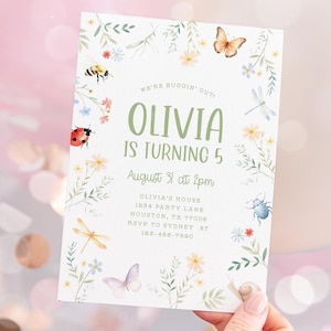 May include: A floral-themed birthday invitation for a girl named Olivia turning 5. The invitation features a green leafy border with colourful flowers, butterflies, ladybugs, and other insects. The text reads "We're Buggin' Out! Olivia is turning 5 August 31 at 2pm Olivia's House 1234 Party Lane Houston, TX 77008 RSVP to Sydney at 123-486-7890"