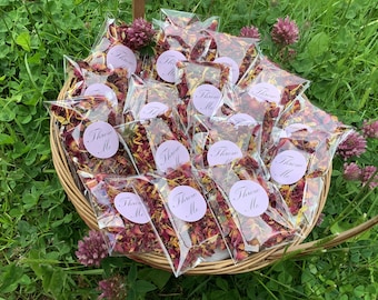 May include: A wicker basket filled with small clear bags of dried rose petals. Each bag has a round sticker that says "Throw Me" in a purple script font.