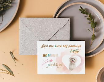 May include: A white card with a pink watercolor heart and a photo of a white dog inside. The card says "Alfie you were my favourite hello and hardest goodbye".